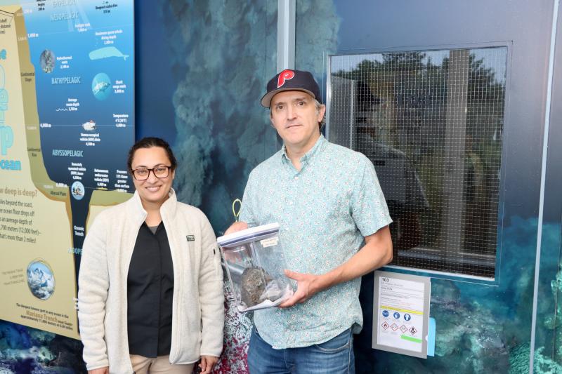 Associate professors Sunita Shah Walter, left, and Andrew Wozniak from the University of Delaware’s School of Marine Science and Policy in Lewes hold a rock collected from a previous trip to the floor of the Pacific Ocean. Wozniak was on a mini submarine April 29, and was the first to witness the immediate aftermath of an undersea volcanic eruption. BILL SHULL PHOTO